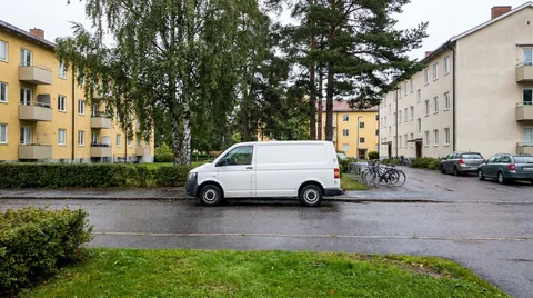 Bostadsgata i en Stockholmsförort med parkerad servicebil